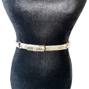 Woman’s gold-tone chain belt is detailed with a gold toned buckle fastening